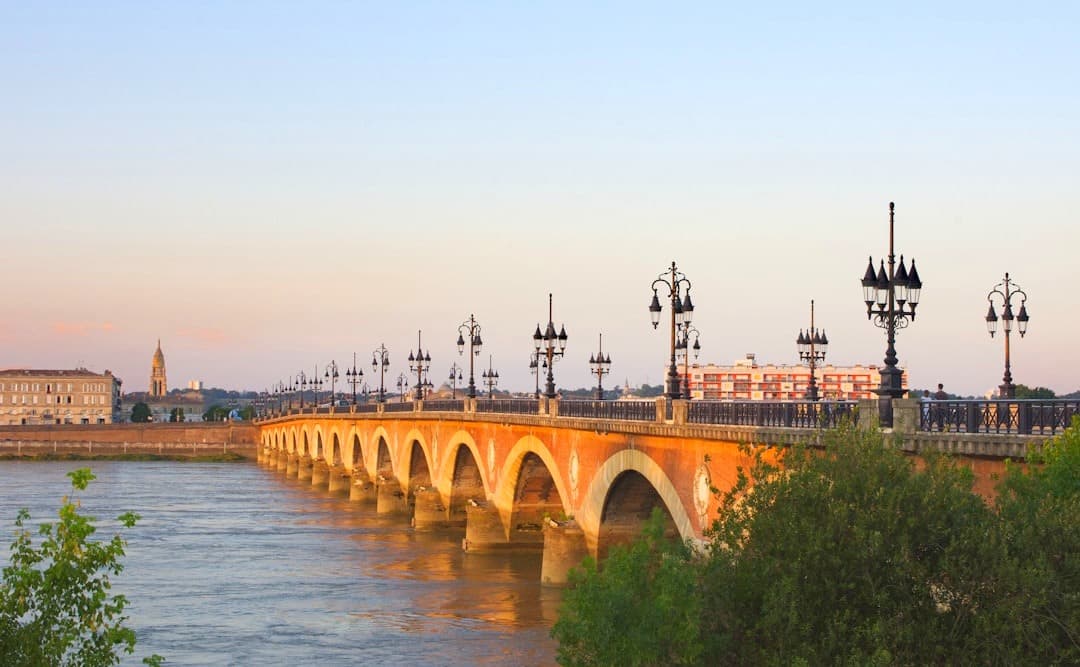 Historyczny most Pont de Pierre w Bordeaux, rzeka Garonna, zachód słońca.