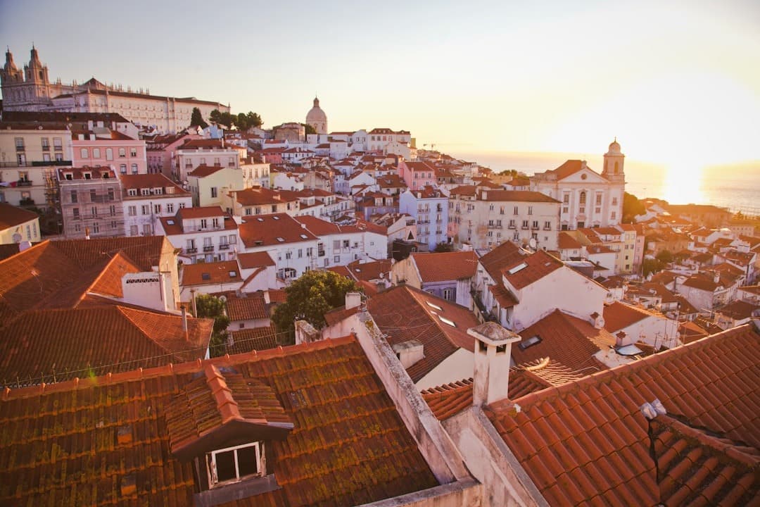 Panorama Lizbony, czerwone dachy, zachód słońca, zabytkowe miasto, Portugalia.
