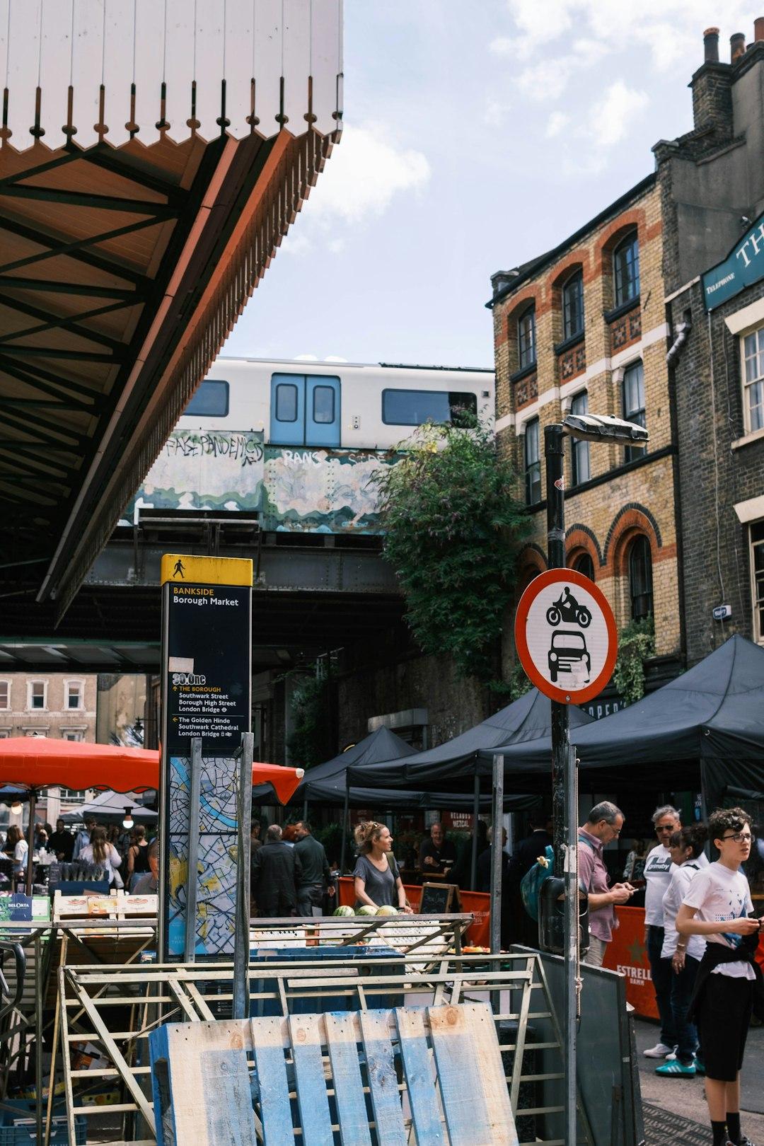 Tętniący życiem targ Borough Market w Londynie z pociągiem na wiadukcie.