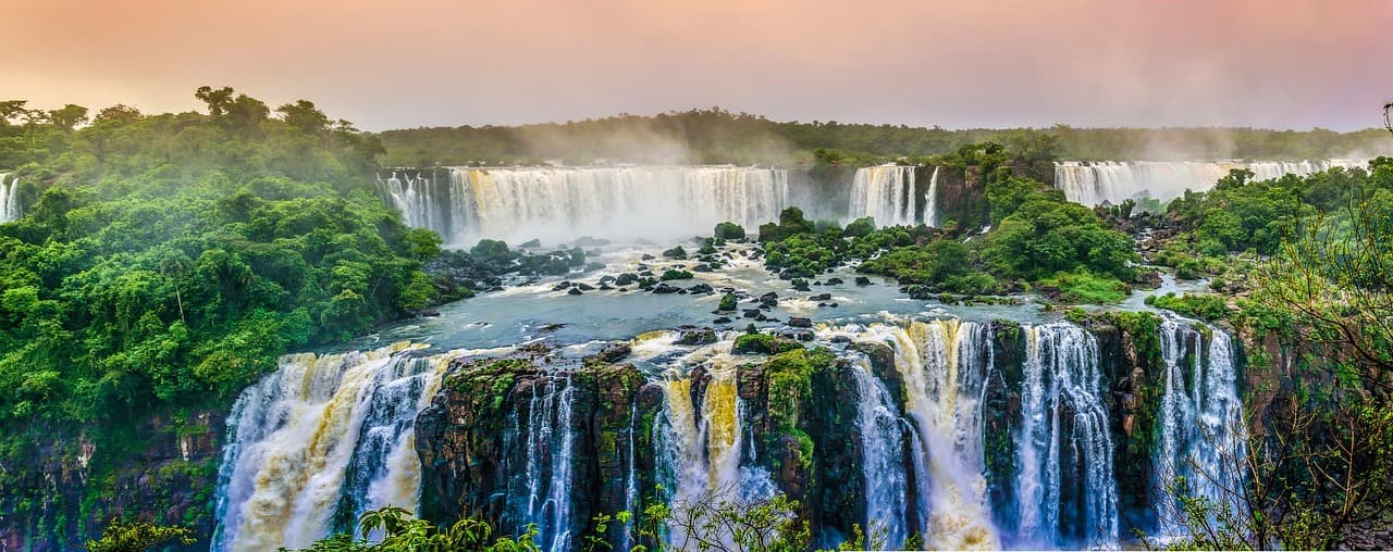 Wodospady Iguazu, panoramiczny widok, tropikalna dżungla, ciepłe światło zachodu.