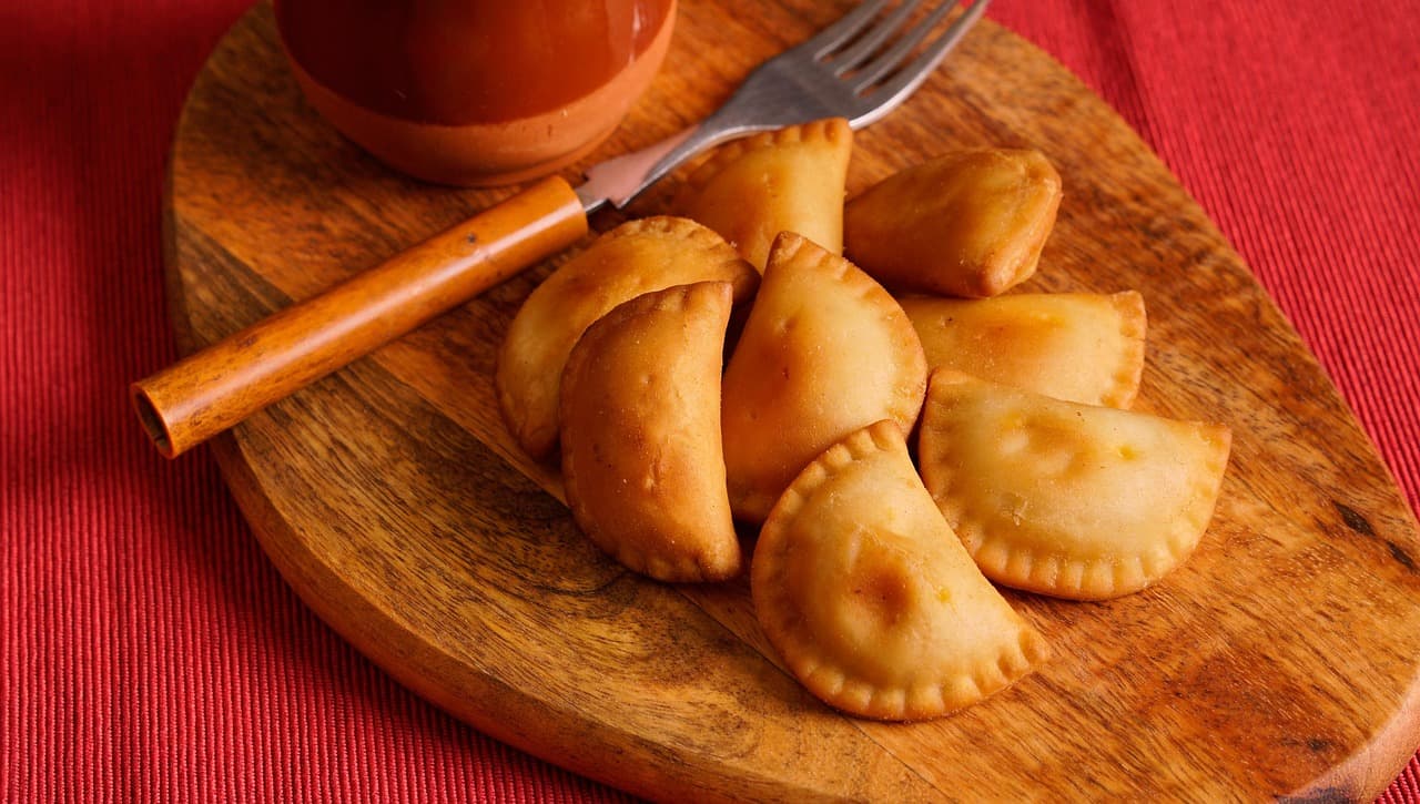 Złocistobrązowe smażone pierożki na drewnianej desce