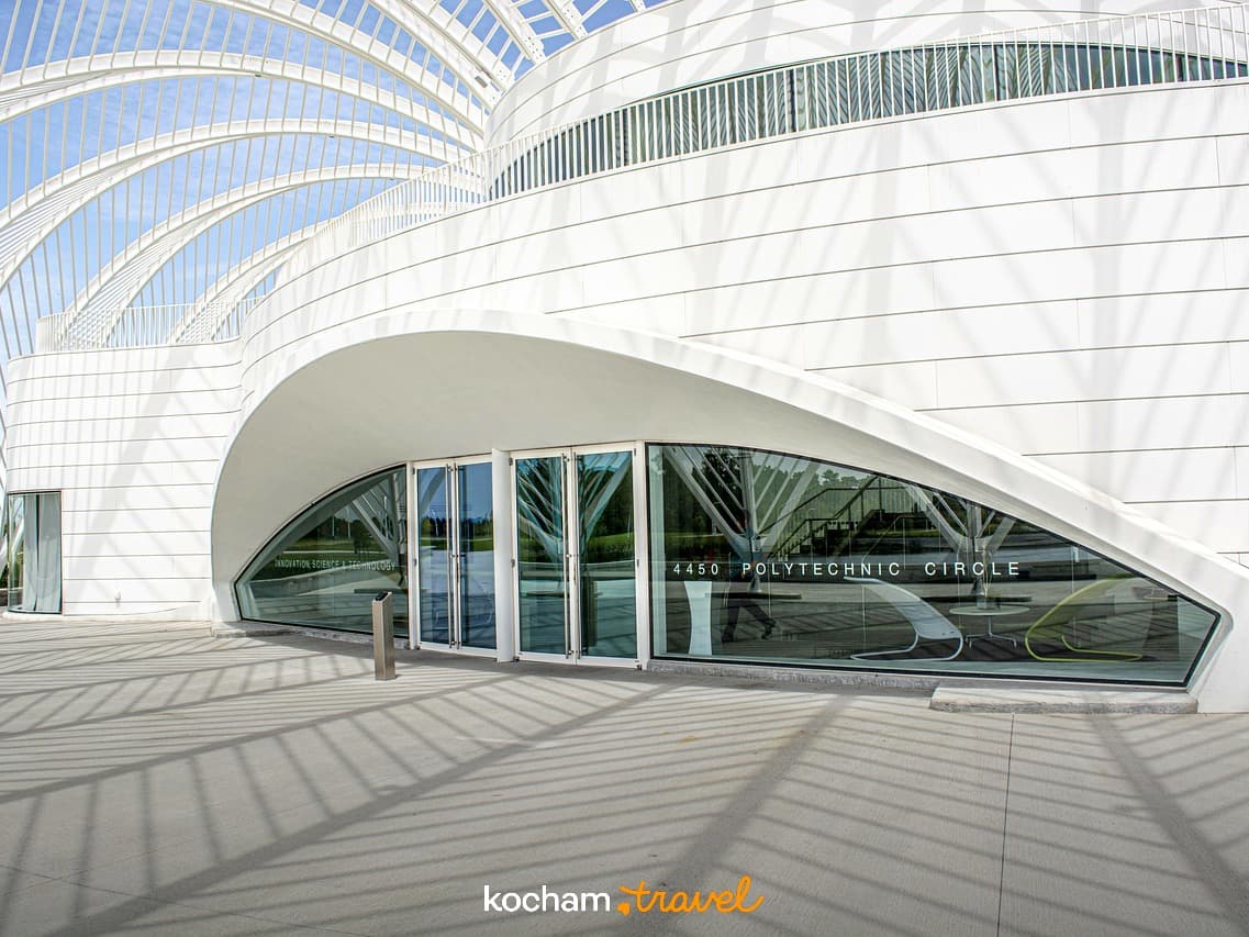 Biała, nowoczesna architektura z łukowatym dachem i cieniami.