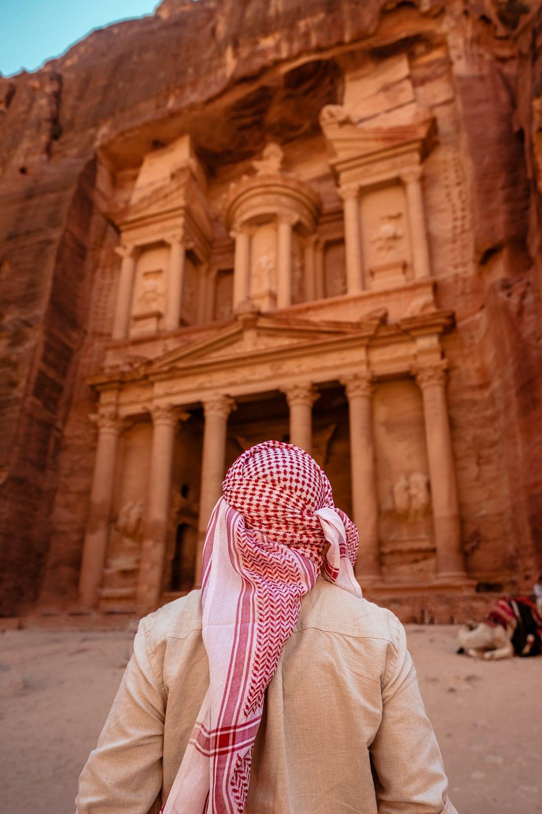Osoba w kefiji podziwiająca Skarbiec Al-Khazneh w Petrze, Jordania.
