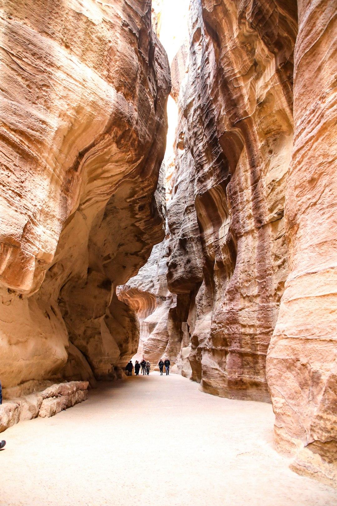 Turyści spacerujący wąskim kanionem Siq w Petrze, Jordania.