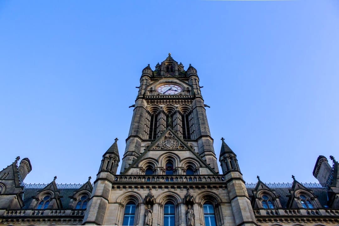 Ratusz Manchester, gotycka wieża zegarowa, błękitne niebo, architektura.