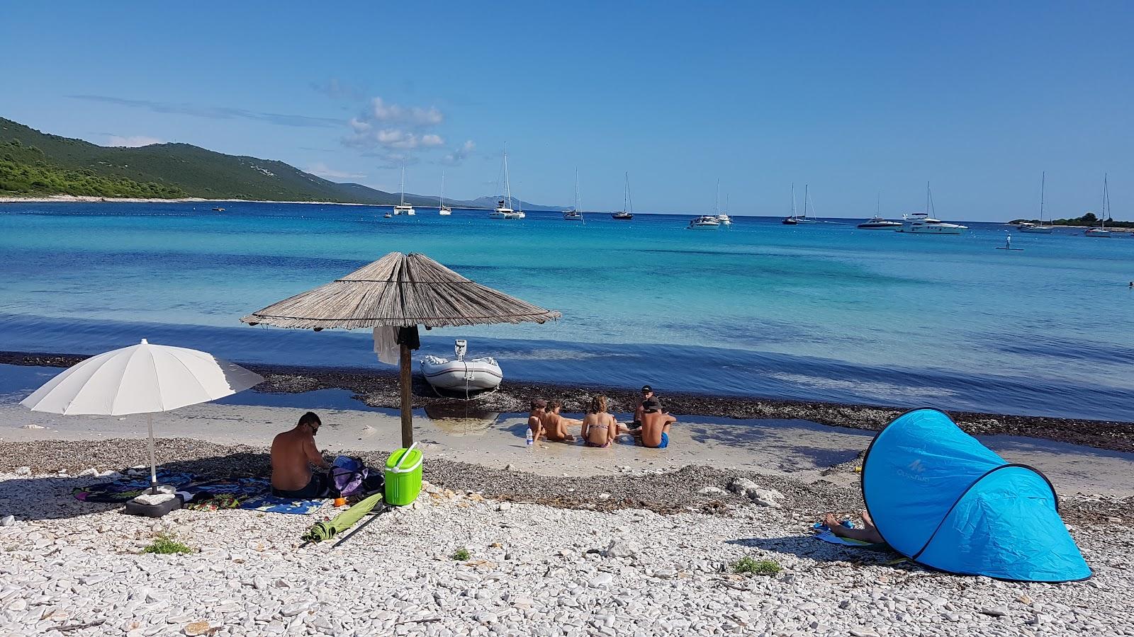 Relaks na plaży z jachtami w tle morza.