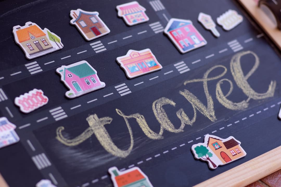 Miniaturowe domki, napis travel, tablica kredowa.