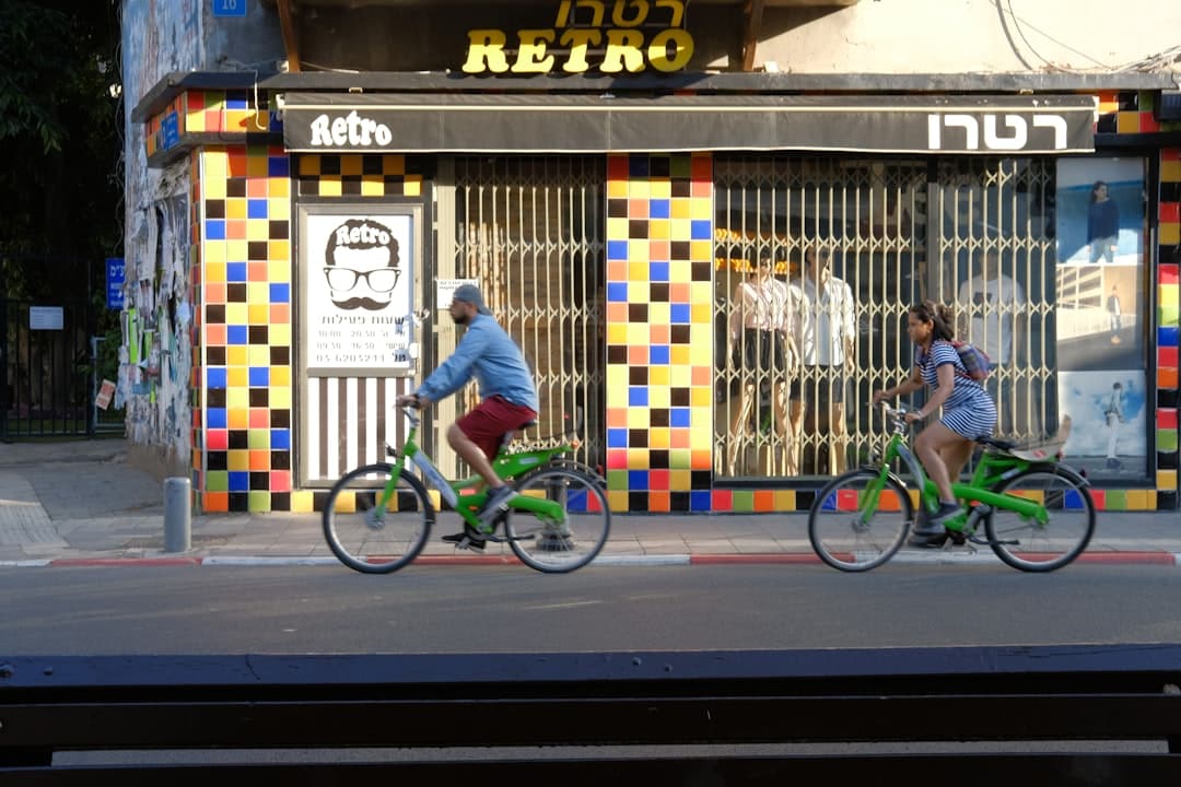 Ludzie na rowerach przed kolorowym sklepem retro