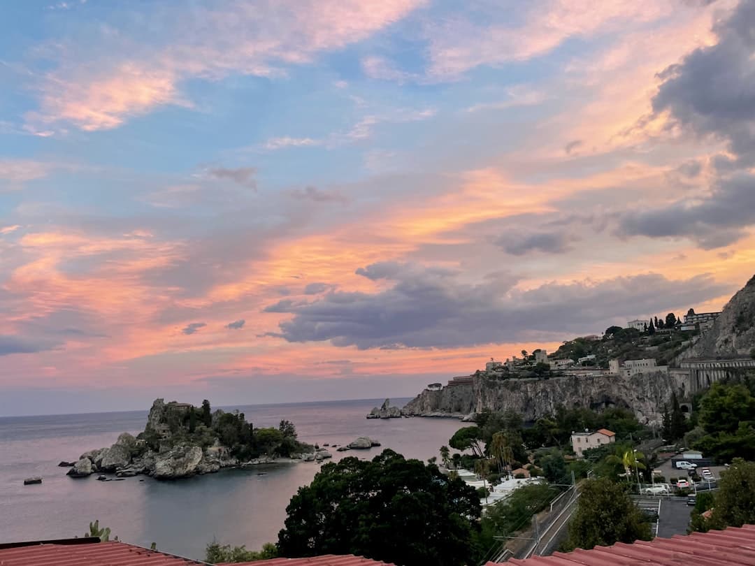 Malowniczy zachód słońca nad Isola Bella i wybrzeżem Taorminy na Sycylii.