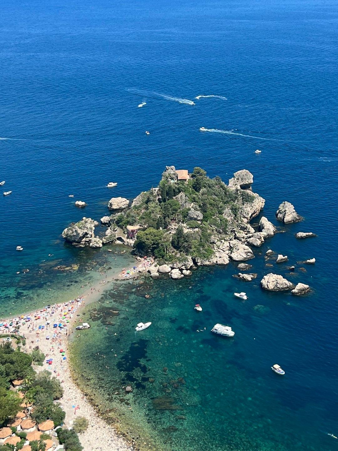 Isola Bella, Taormina, Sycylia: skalista wyspa, plaża, turkusowe morze i łodzie.