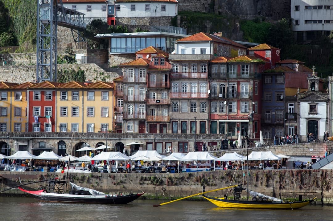 Kolorowe budynki, rzeka Douro, łodzie rabelo i targ w Porto, Portugalia.