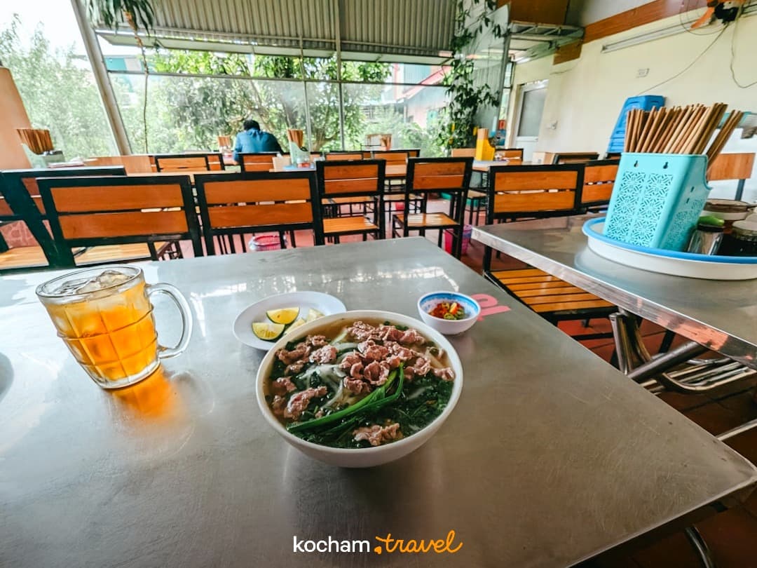 Wietnamska zupa pho, mrożona herbata na metalowym stole w restauracji.