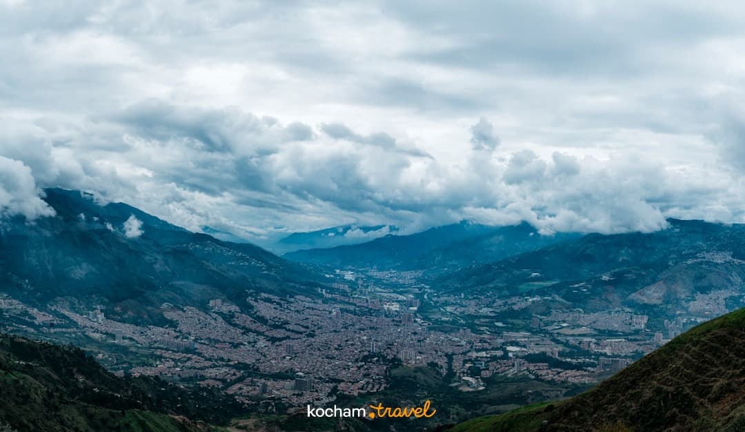Panoramiczny widok miasta w dolinie otoczonej górami i chmurami