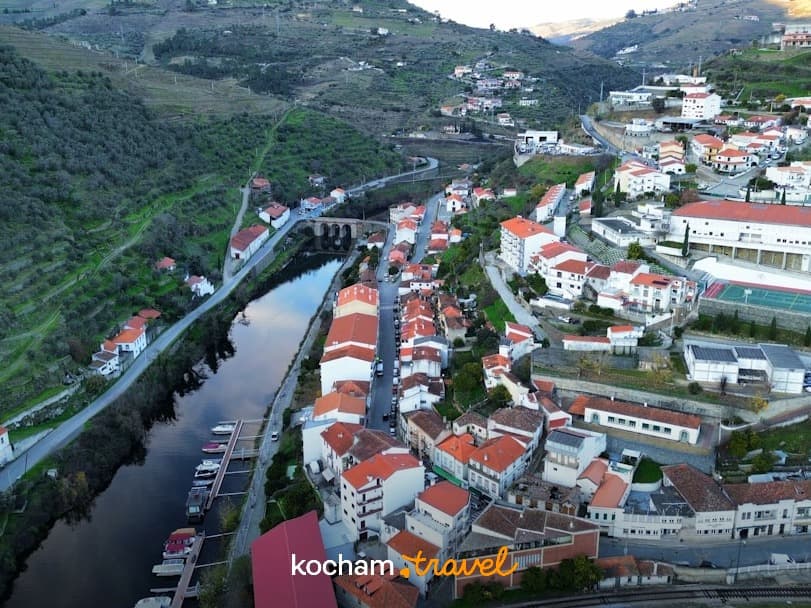Panoramiczny widok na miasteczko nad rzeką w dolinie, tarasowe wzgórza.