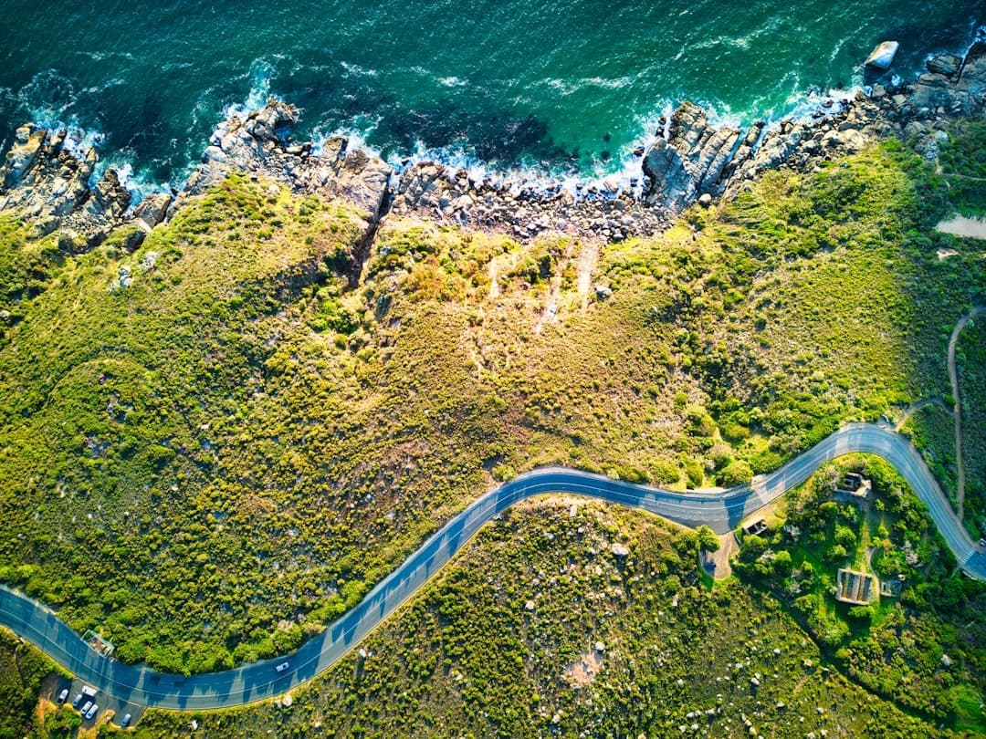 Wygibista droga nadmorska, zielone wzgórza, turkusowy ocean, widok z lotu ptaka