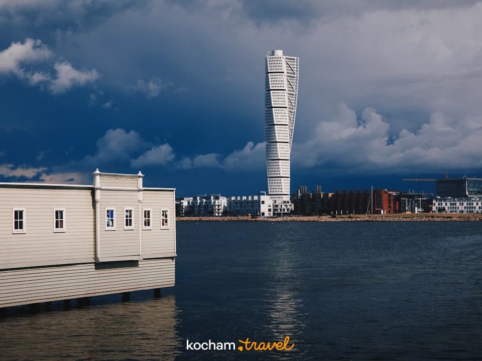 Turning Torso, Malmö, Szwecja. Nowoczesna architektura, wieżowiec nad wodą, dramatyczne chmury.