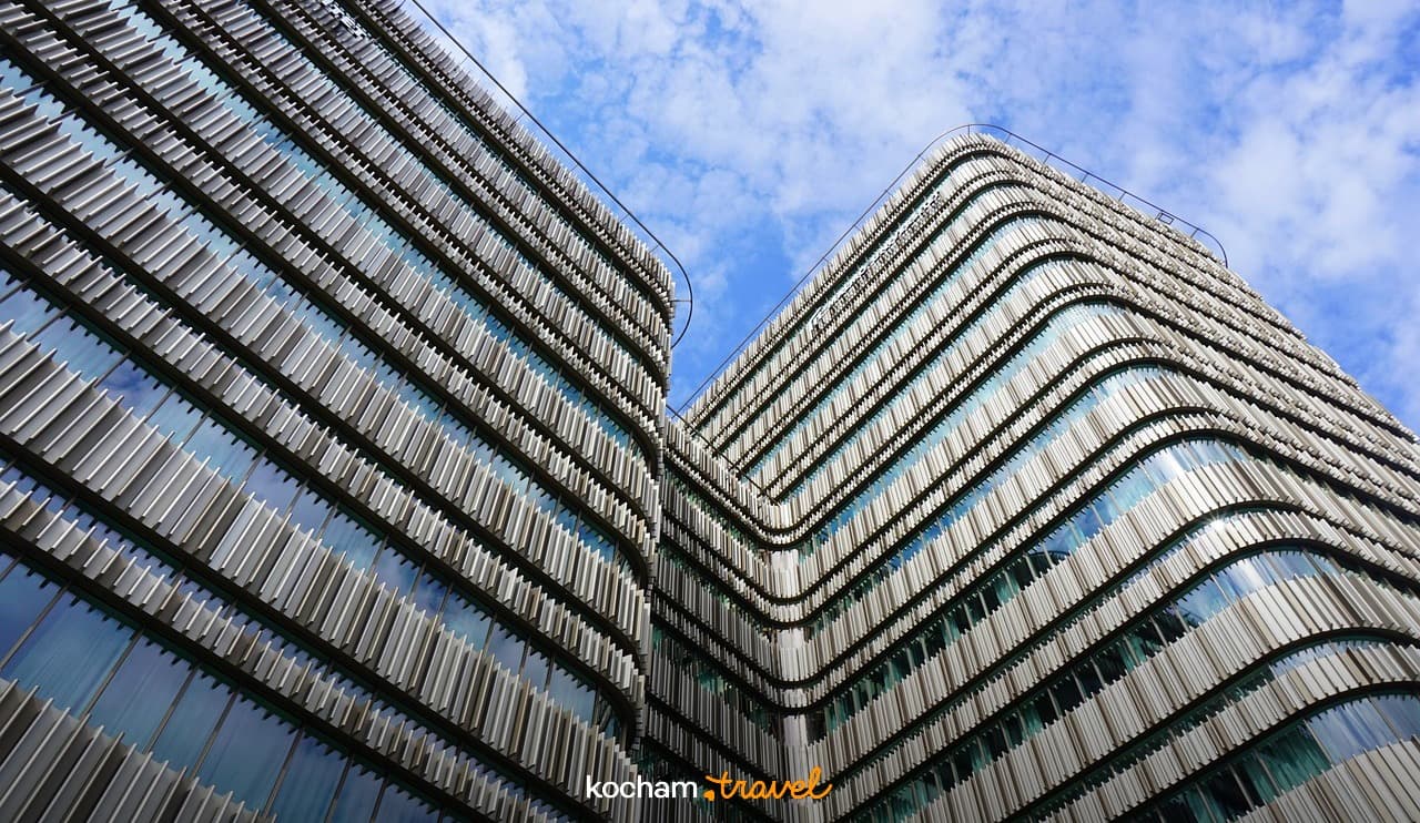 Nowoczesny budynek, falista fasada, błękitne niebo, architektura miejska.