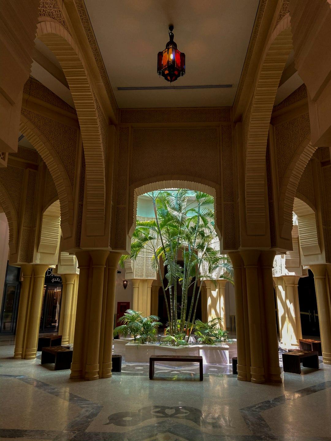 Wystawny dziedziniec wewnętrzny z palmami i arabską architekturą.