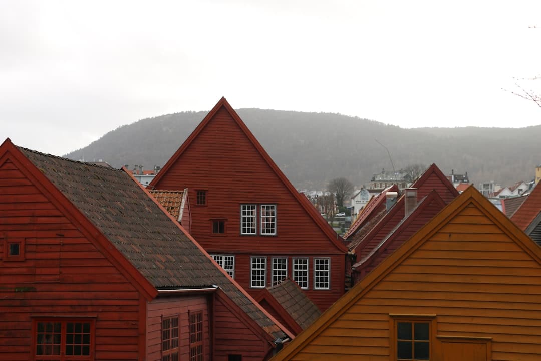 Kolorowe drewniane domy Bryggen w Bergen, Norwegia, na tle gór.