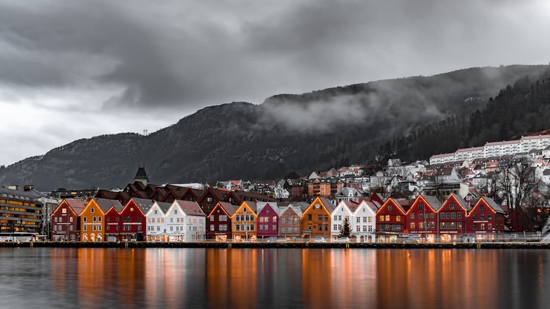 Bergen, Norwegia: kolorowe budynki Bryggen nad wodą, mgliste góry.