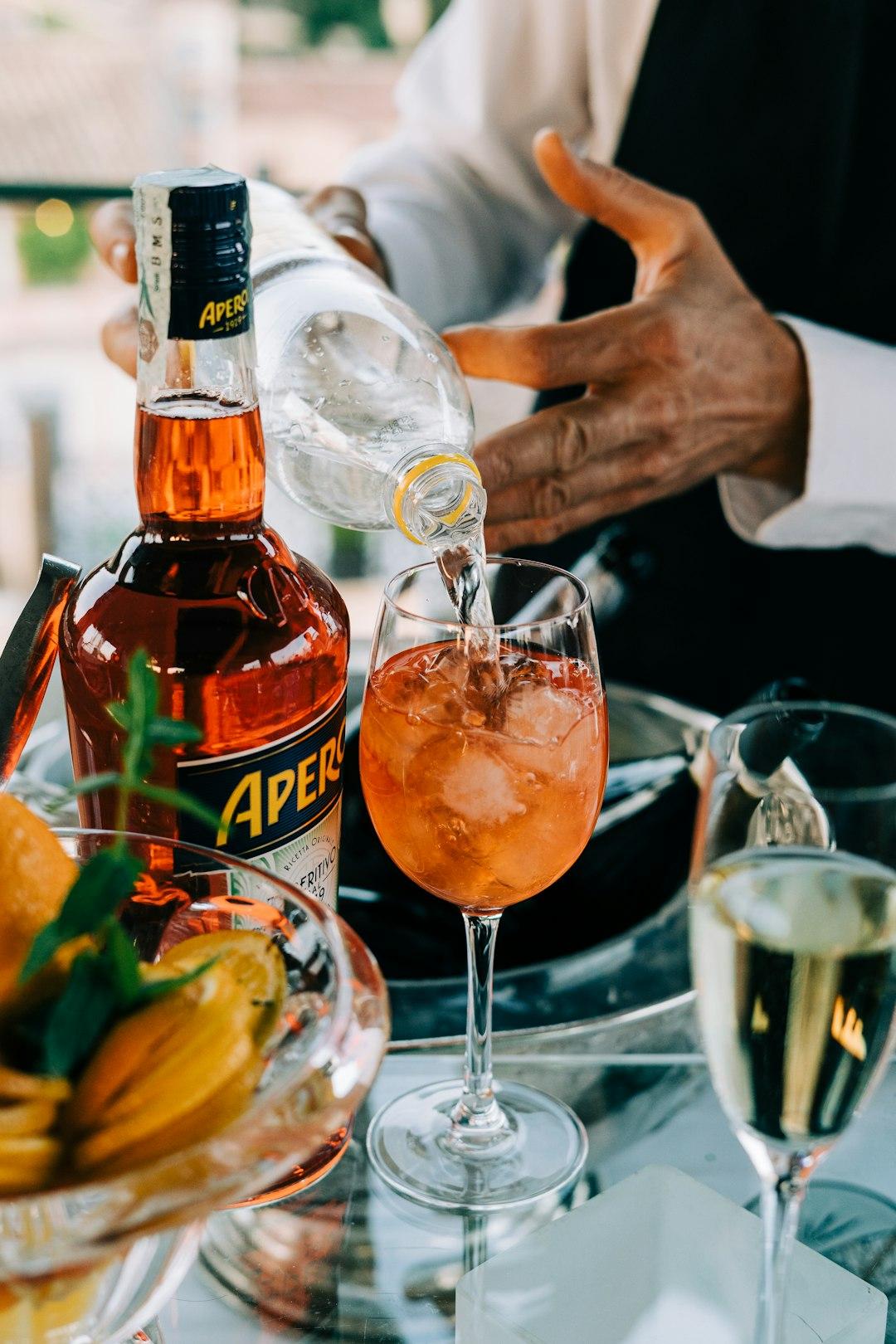 Barman przygotowuje orzeźwiający koktajl Aperol Spritz z lodem i pomarańczą.