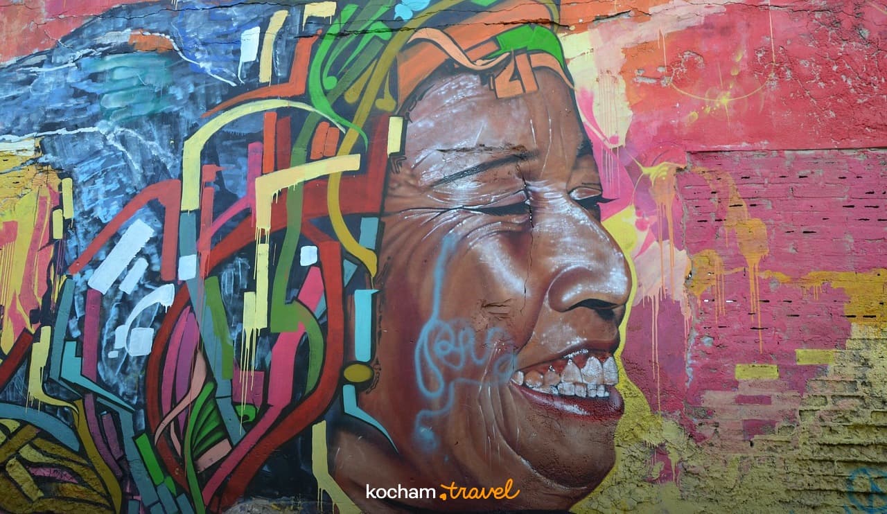 Kolorowe graffiti mural z uśmiechniętą twarzą na miejskiej ścianie.
