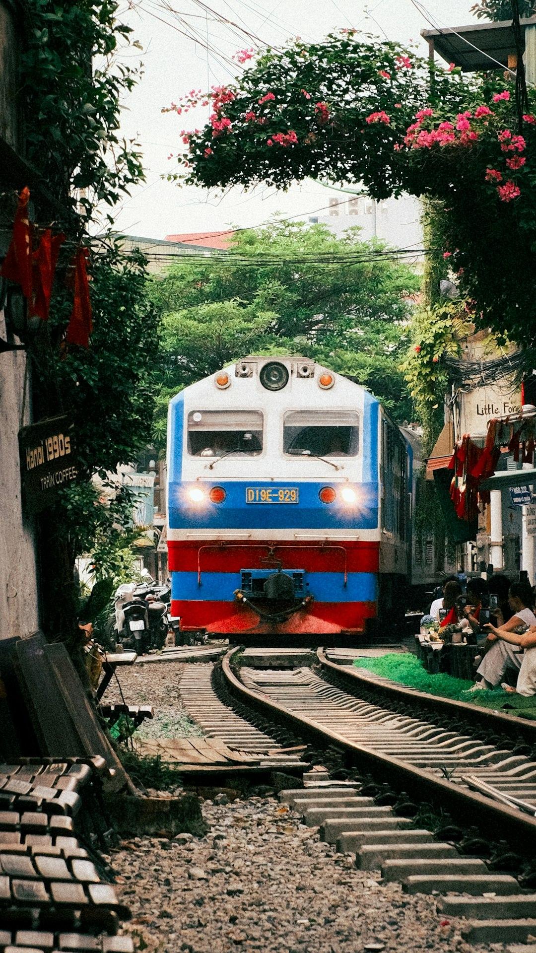 Pociąg na ulicy kolejowej Hanoi z ludźmi w kawiarniach