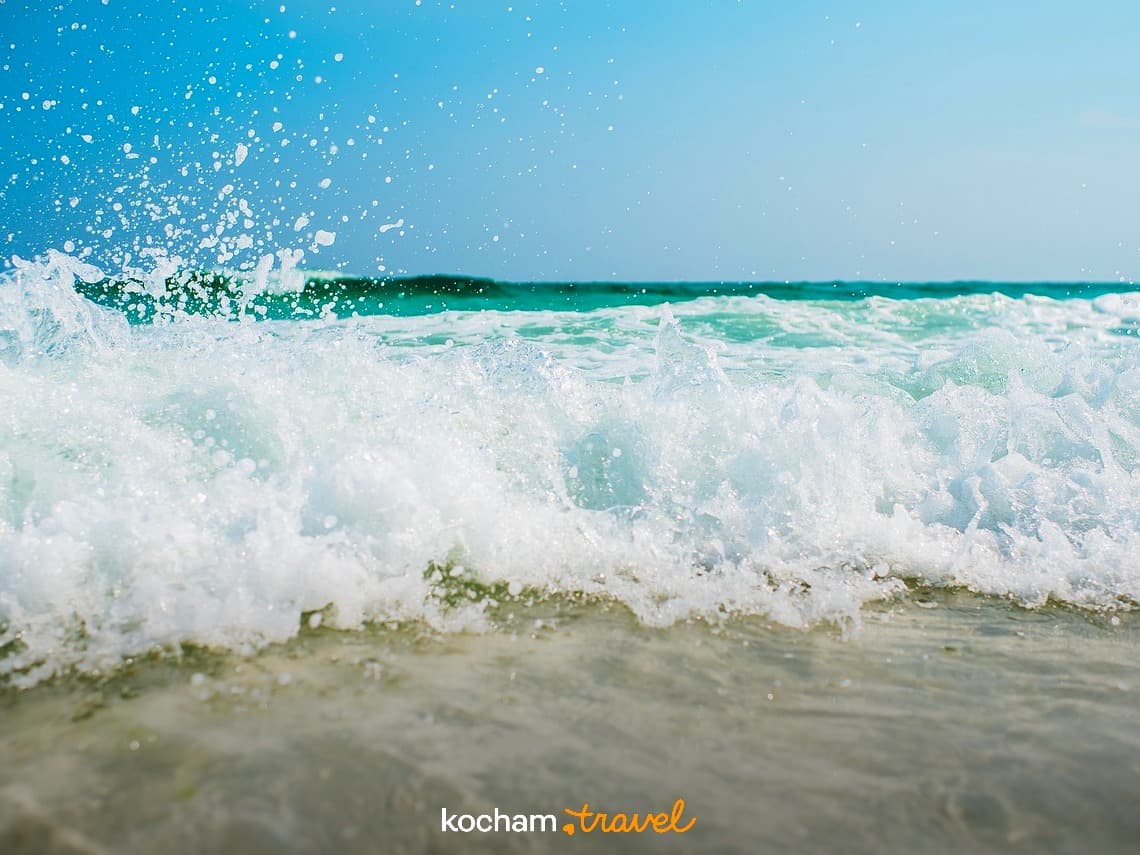 Fala oceanu, turkusowa woda, plaża, błękitne niebo, letnie wakacje.