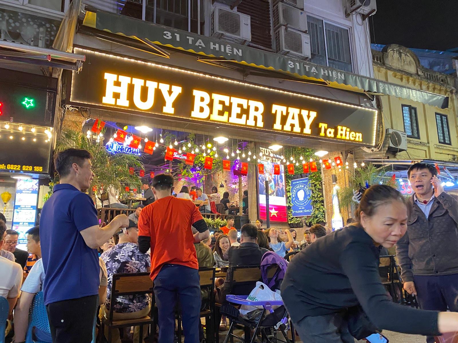 Wietnamski bar piwny nocą pełen ludzi
