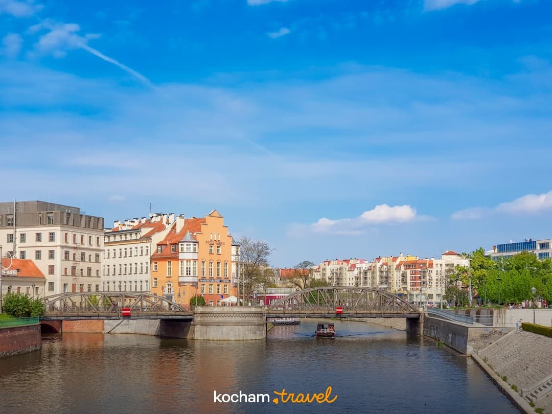 Wrocław, rzeka, historyczne mosty, kolorowe budynki, słoneczne miasto.