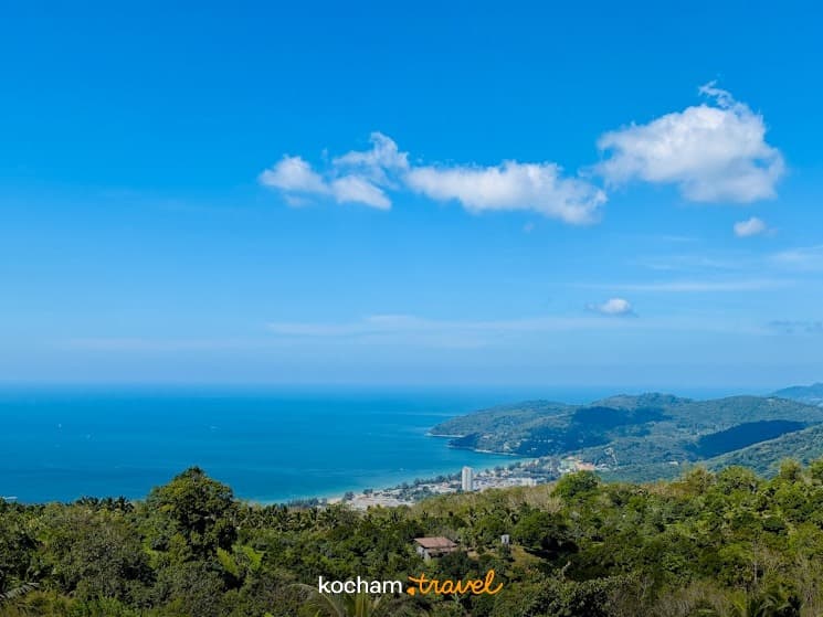 Panoramiczny widok na tropikalne wybrzeże, zielone wzgórza, błękitne morze, plażę i kurort.