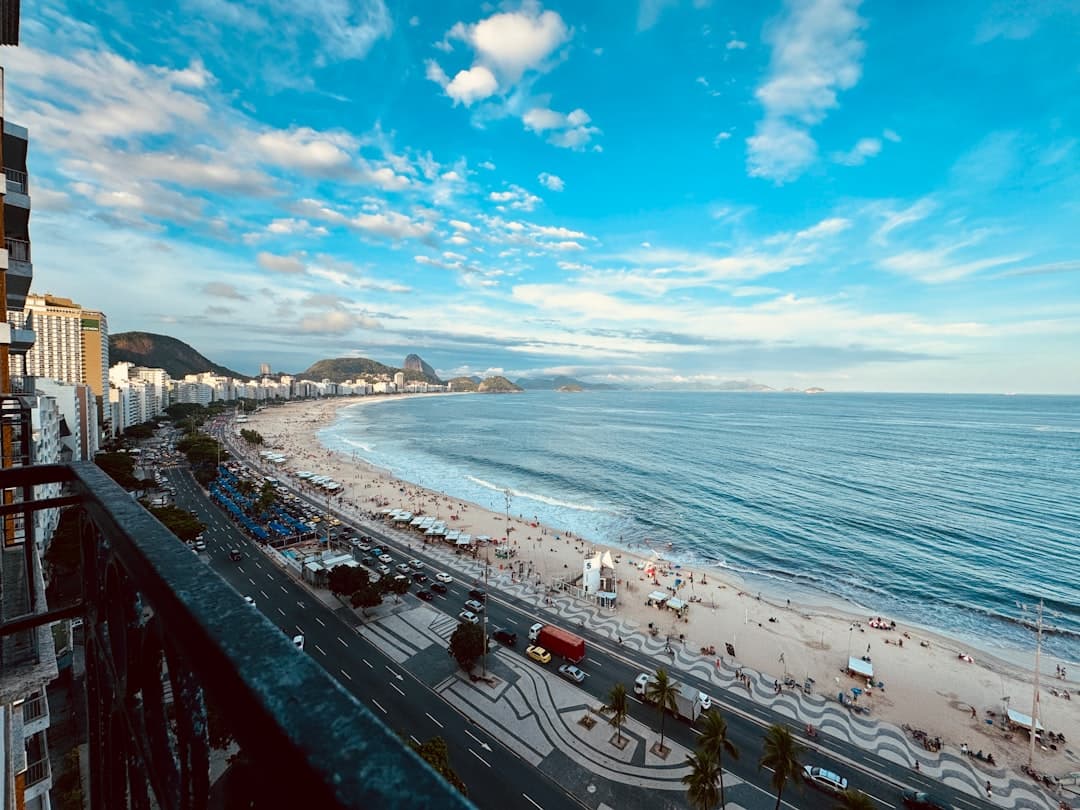 Tętniąca życiem plaża Copacabana, ocean, promenada i panorama Rio de Janeiro.