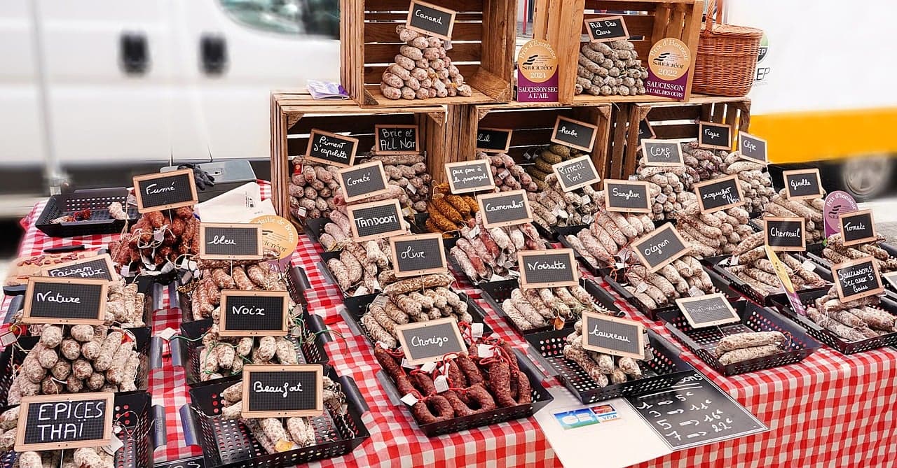 Francuskie suszone kiełbasy (saucisson) na stoisku targowym, różne smaki.