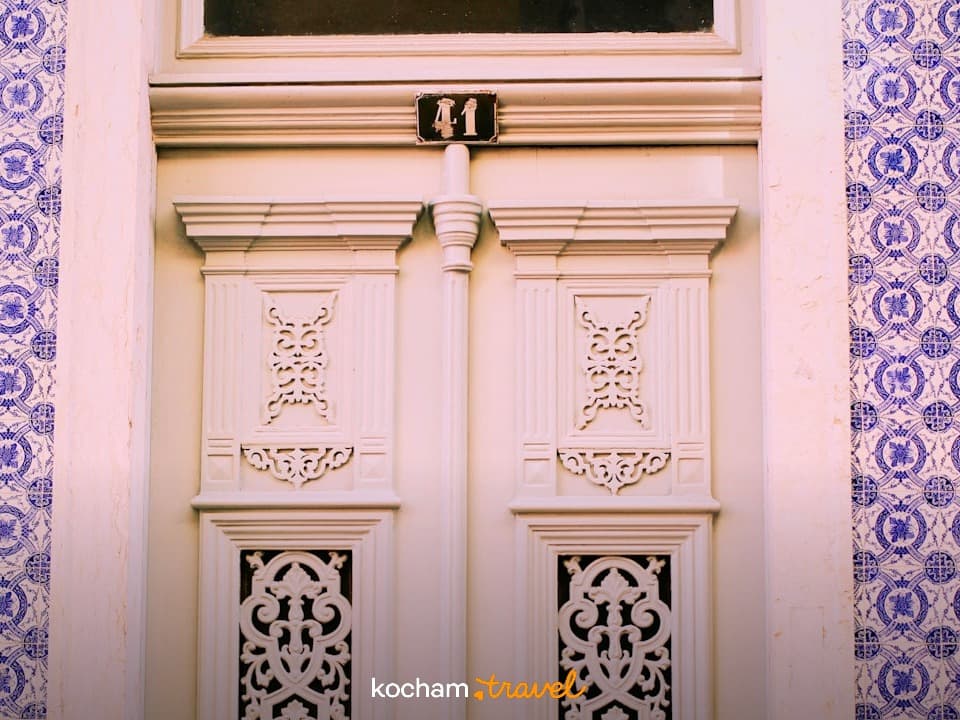 Białe, rzeźbione drzwi z numerem 41, niebieskie azulejos.