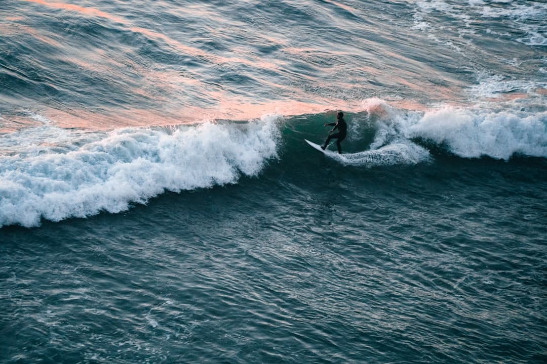 Surfer na fali oceanicznej podczas zachodu słońca