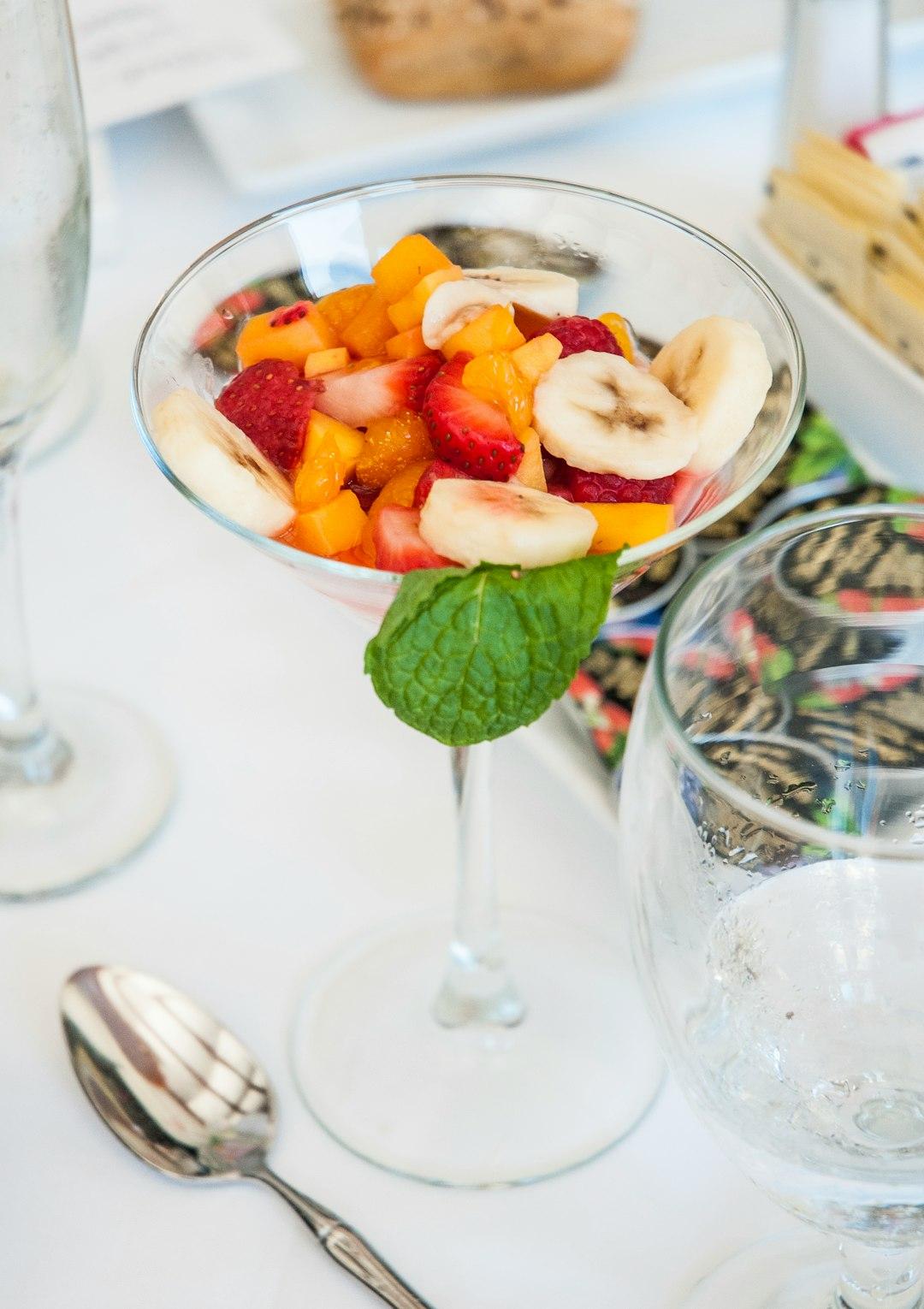 Świeża sałatka owocowa z truskawkami, bananami, mango i miętą.