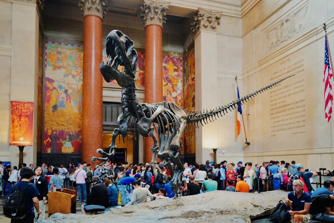 Szkielet dinozaura w muzeum z dużą grupą ludzi.