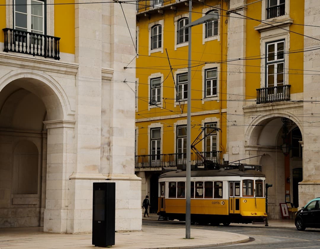 Żółty tramwaj w Lizbonie, historyczne budynki, uliczny widok miasta.