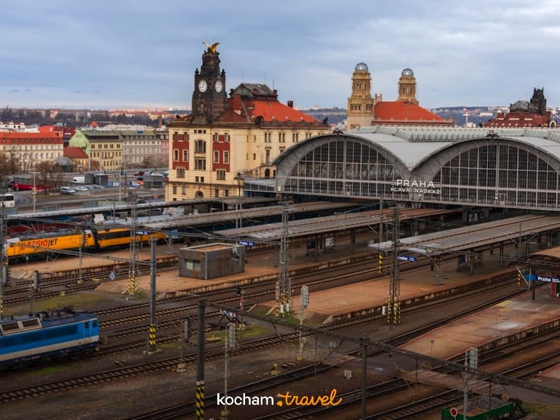 Główny Dworzec Kolejowy w Pradze: tory, pociągi, historyczny budynek stacji.