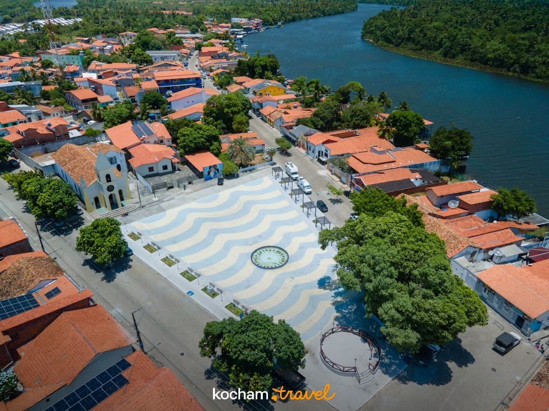 Malownicze miasteczko nad rzeką, kościół, plac, pomarańczowe dachy.