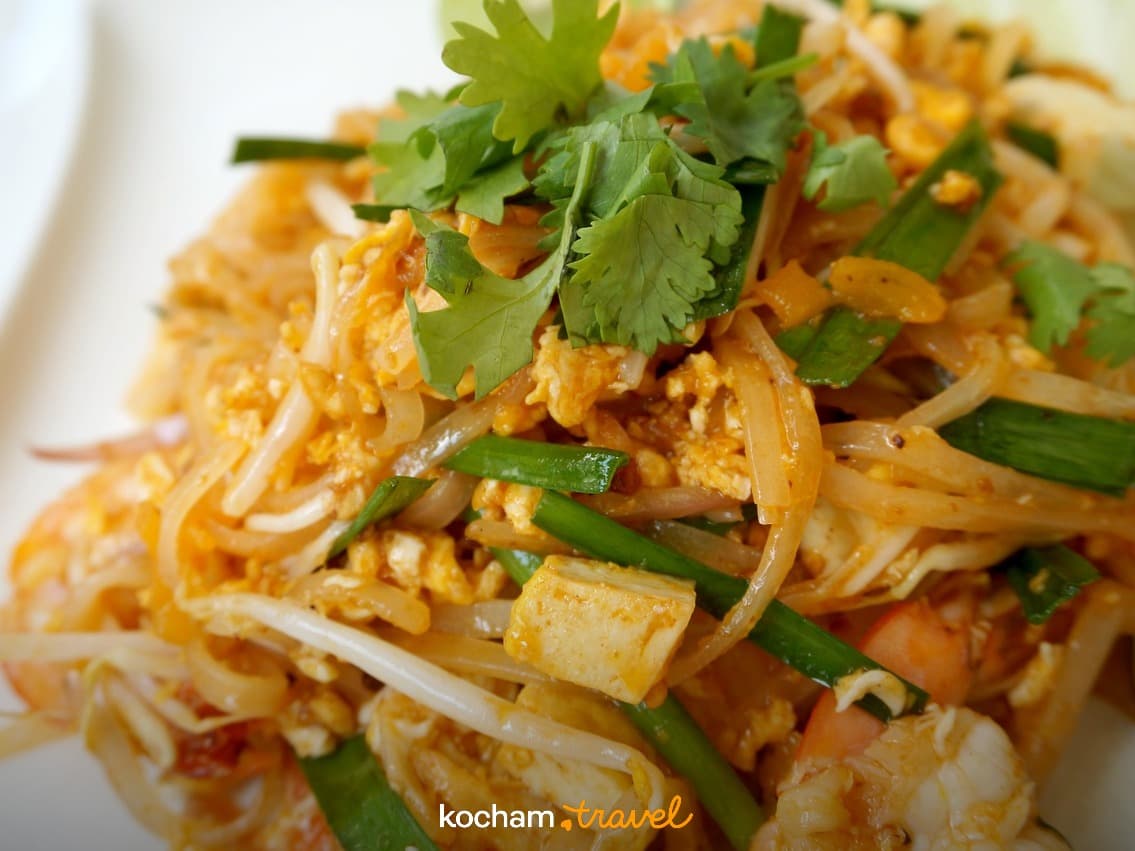 Pad Thai z krewetkami, makaronem, tofu i świeżymi ziołami.