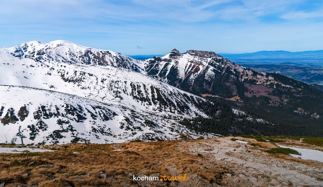 Ośnieżone góry, panorama Tatr, słoneczny dzień, górski krajobraz.