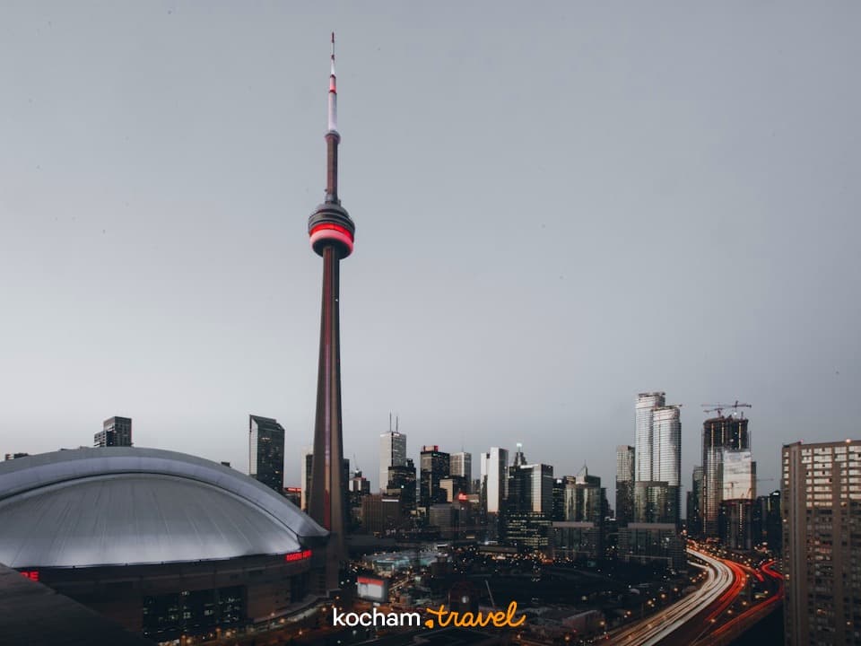 Nocna panorama Toronto: Wieża CN, Rogers Centre, smugi świateł samochodów.