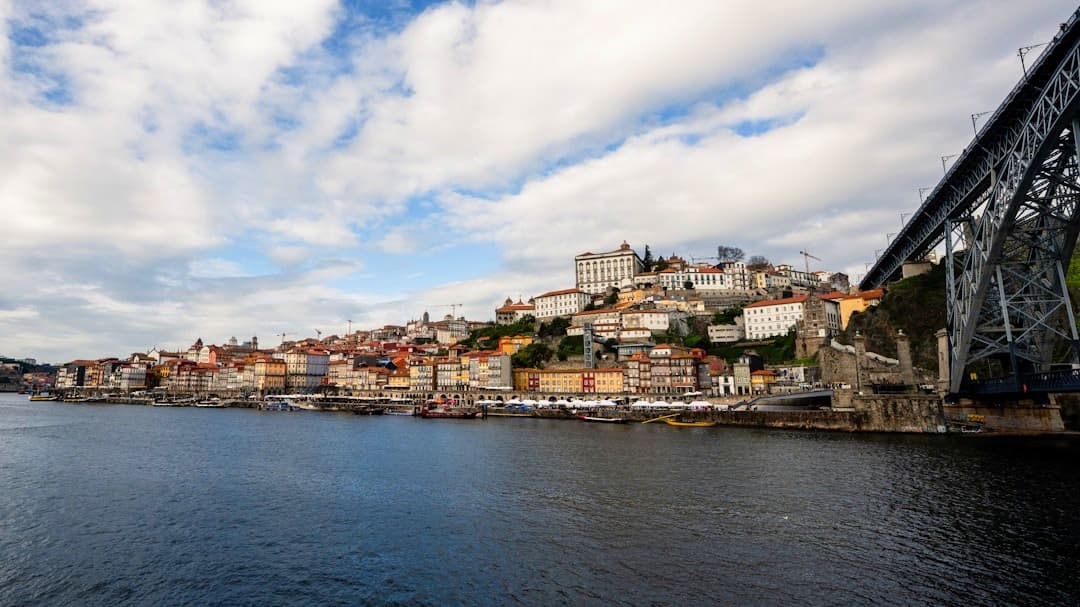 Porto, Portugalia: panorama kolorowych kamienic nad rzeką Douro z mostem.