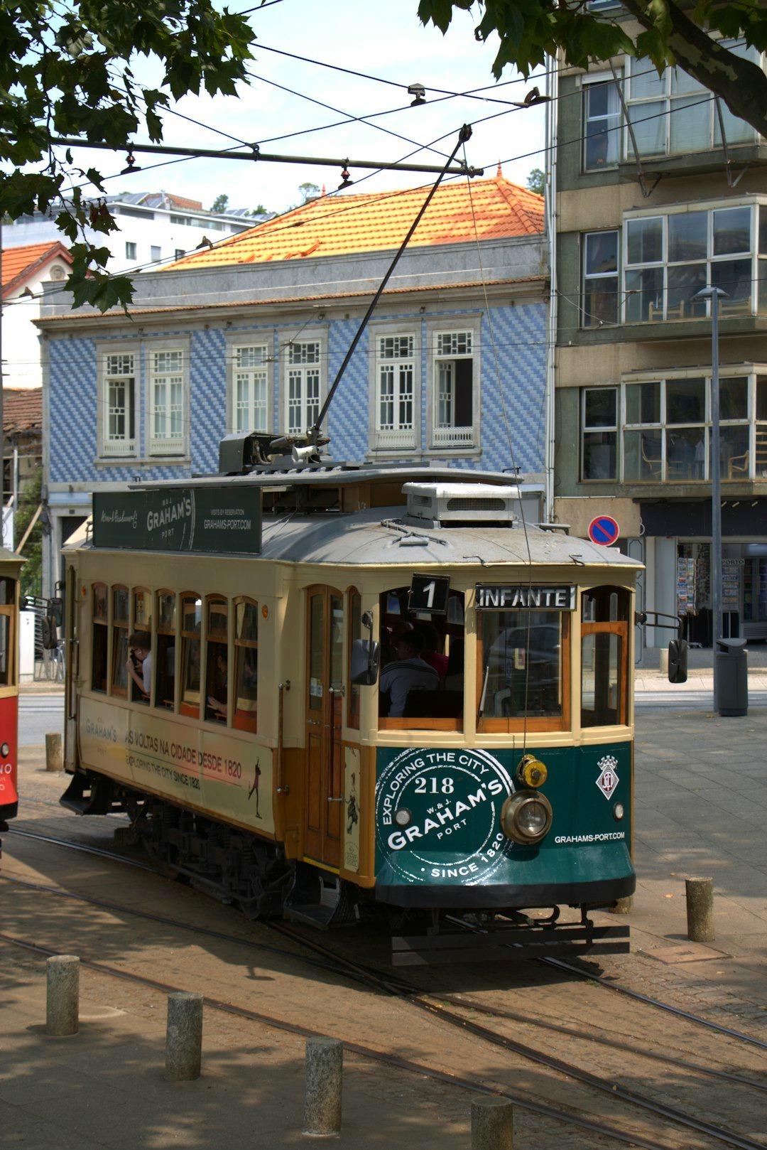Zabytkowy tramwaj w Porto, niebiesko-biały budynek, słoneczny dzień, Portugalia.