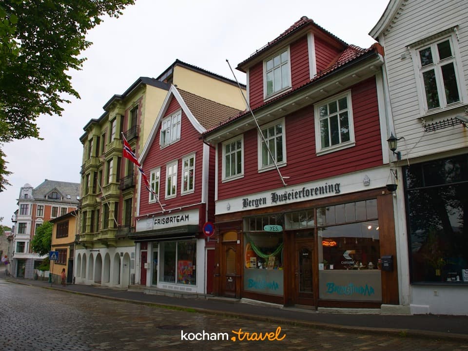 Tradycyjne budynki i sklepy przy brukowanej ulicy w Bergen, Norwegia.