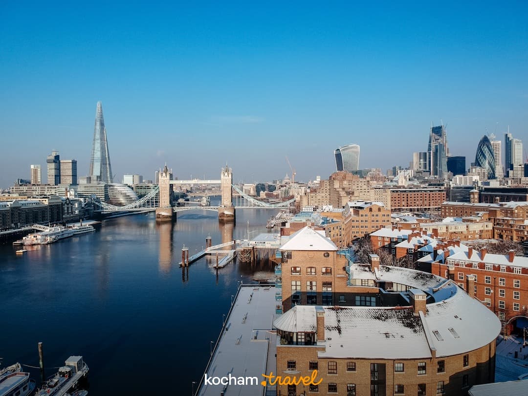 Panorama Londynu z Tower Bridge i The Shard, zaśnieżone budynki.