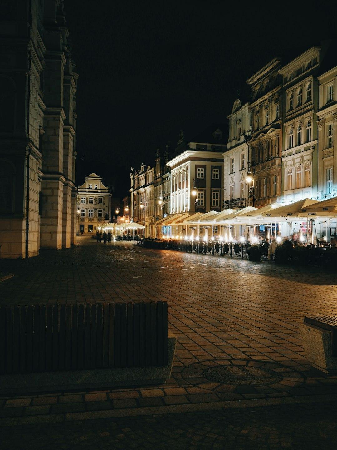 Nocny Rynek w Poznaniu, oświetlone historyczne budynki i restauracje.