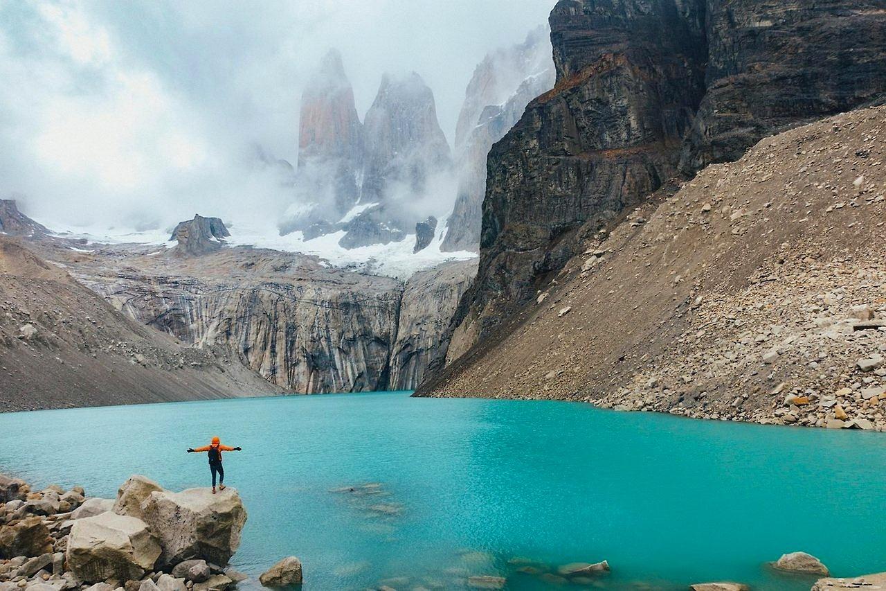 Trekker nad turkusowym jeziorem, góry Torres del Paine.