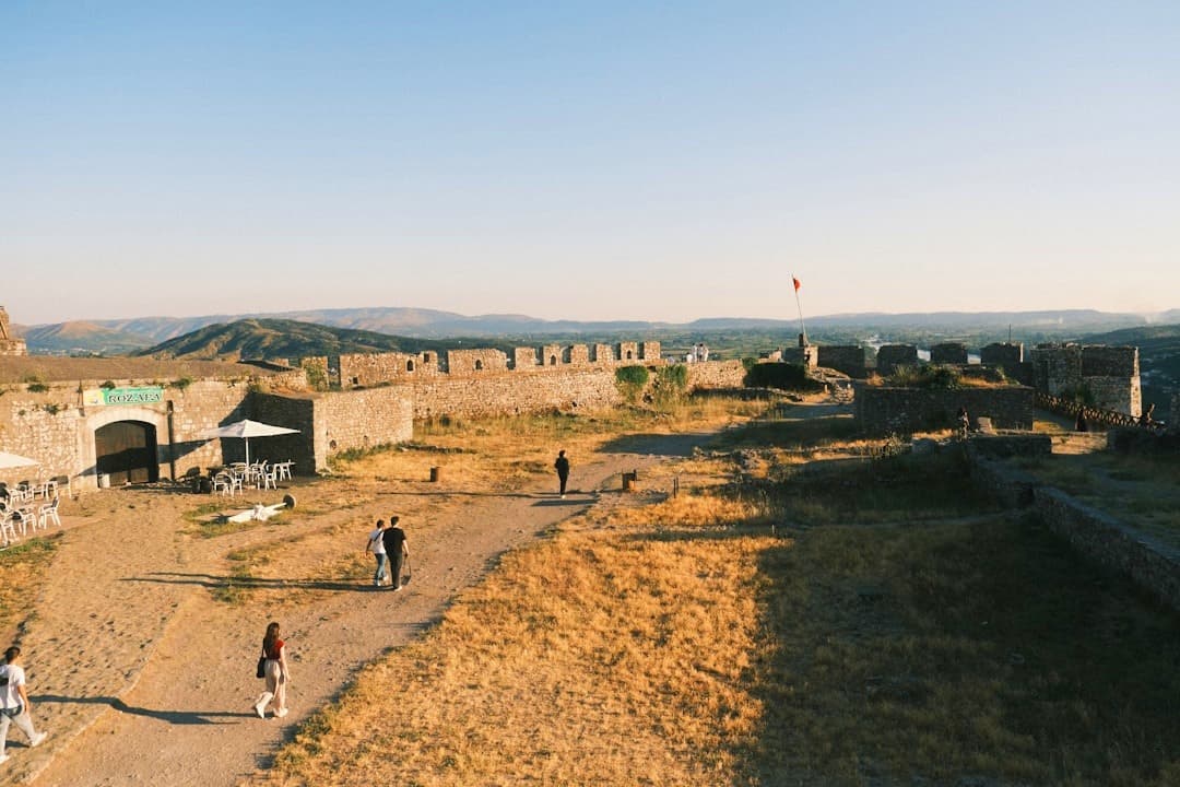 Zamek Rozafa, Albania: rozległe kamienne ruiny, turyści, górski krajobraz.